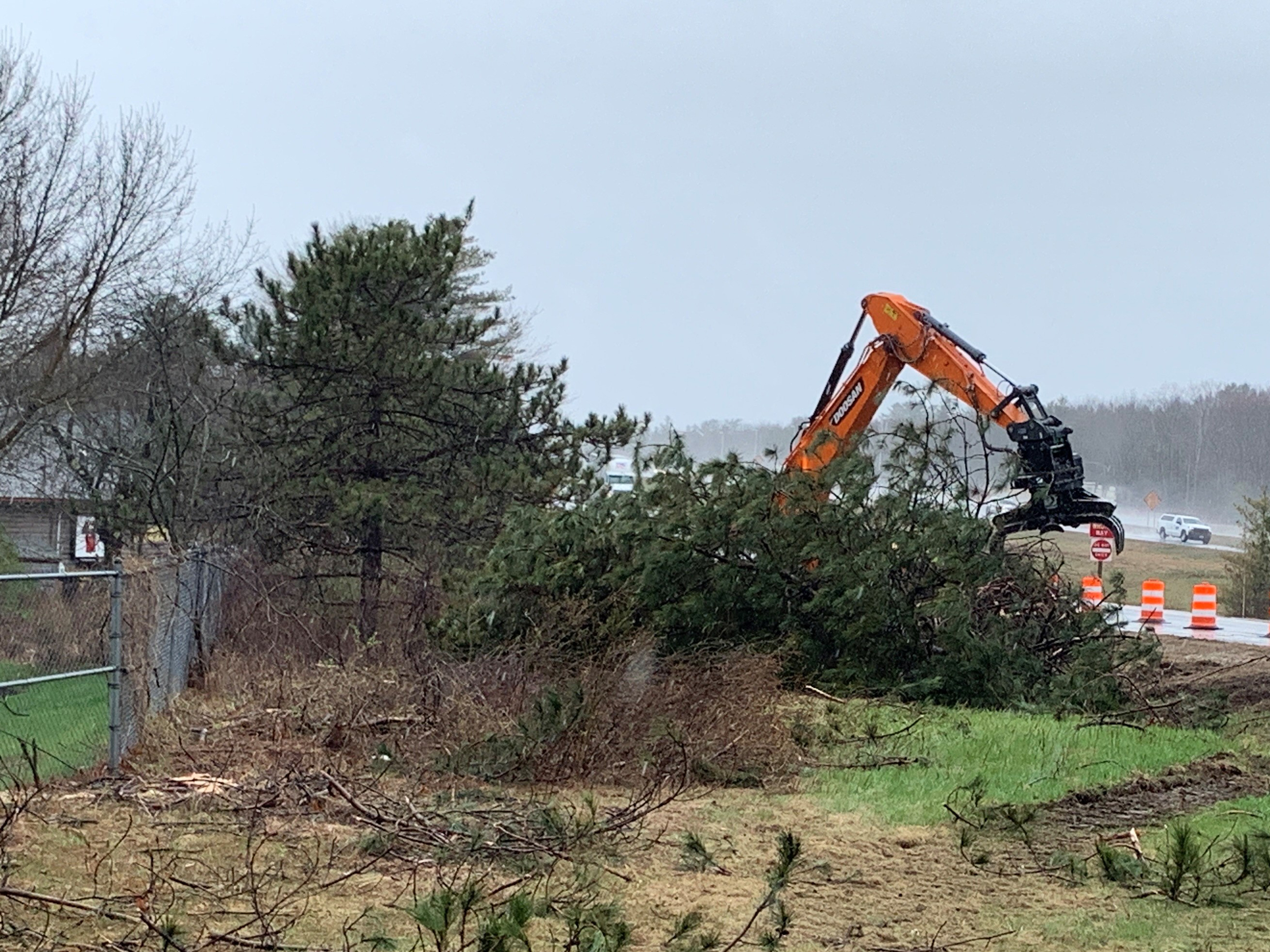 Machinery lifting brush and plants from project site